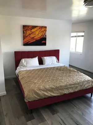a bed in a bedroom with a red headboard at 4 bedroom and 3 bath home close to universal studio and Hollywood in Sherman Oaks