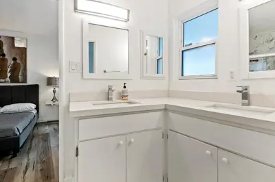 a white bathroom with two sinks and a bed at 4 bedroom and 3 bath home close to universal studio and Hollywood in Sherman Oaks