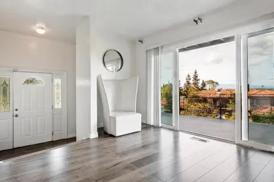 a white room with a white chair and a sliding glass door at 4 bedroom and 3 bath home close to universal studio and Hollywood in Sherman Oaks