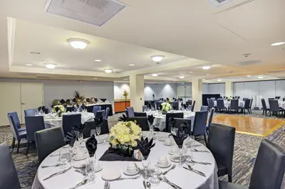 a banquet hall with white tables and chairs at Embassy Suites Valencia in Valencia