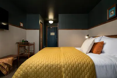 a bedroom with a large bed with a yellow blanket at Hotel Marina Riviera in Big Bear Lake