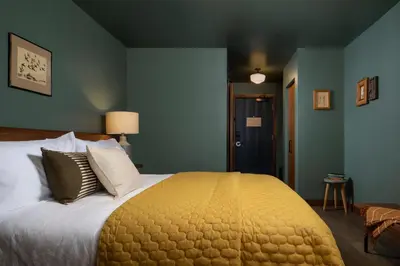 a bedroom with a large bed with a yellow blanket at Hotel Marina Riviera in Big Bear Lake