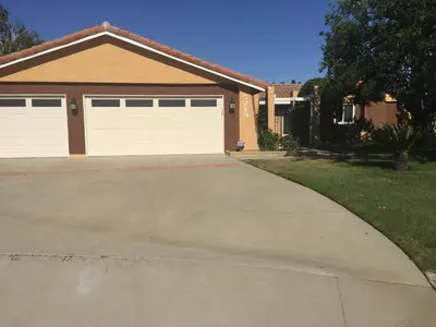 a house with two garage doors and a driveway at Beautiful Foothill Home in Rancho Cucamonga