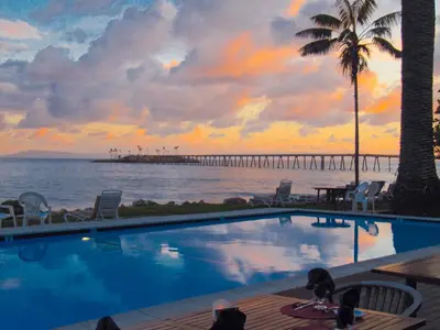 a swimming pool with a view of the ocean and a pier at Cliff House Inn in Carpinteria