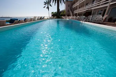 a large blue swimming pool next to the ocean at Cliff House Inn in Carpinteria