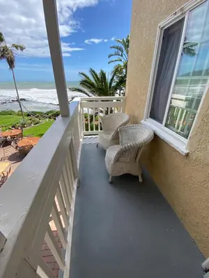 a balcony with chairs and a view of the ocean at Cliff House Inn in Carpinteria