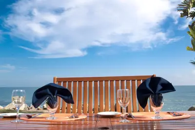 a wooden table with wine glasses on top of it at Cliff House Inn in Carpinteria