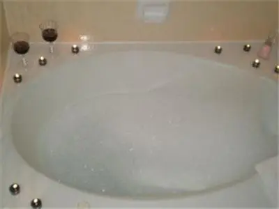 a white bath tub with two glasses in it at Ontario Inn & Suites in Montclair