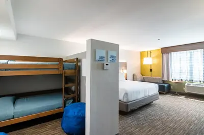 a hotel room with a bed and bunk beds at Holiday Inn Express & Suites Camarillo by IHG in Camarillo