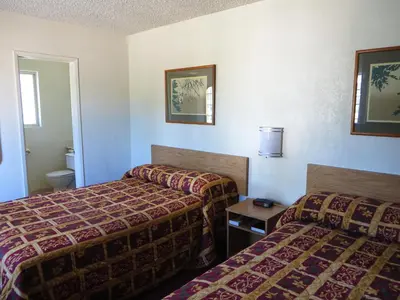 a hotel room with two beds and a toilet at American Inn in Ontario