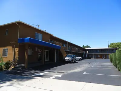 a building with a car parked in a parking lot at American Inn in Ontario