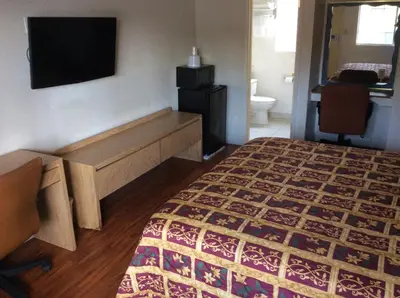 a hotel room with a bed and a television at American Inn in Ontario