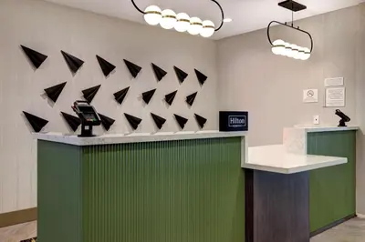 a lobby with a green counter with black triangles on the wall at Doubletree By Hilton Palmdale, Ca in Palmdale