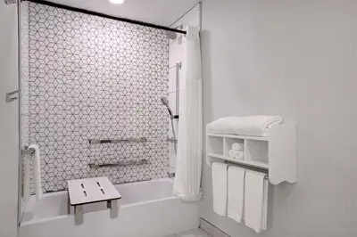 a white bathroom with a shower and white towels at Doubletree By Hilton Palmdale, Ca in Palmdale