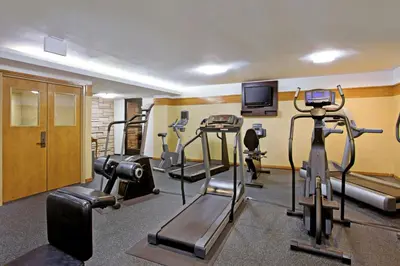 a gym with several tread machines and a flat screen tv at Four Points by Sheraton Ventura Harbor Resort in Ventura
