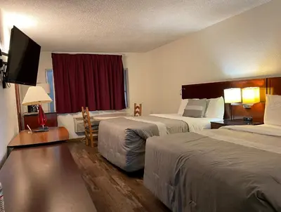 a hotel room with two beds and a flat screen tv at Travelers Beach Inn in Ventura