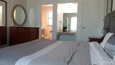 a bedroom with a large bed and a mirror at Travelers Beach Inn in Ventura