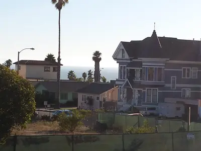 a house with a palm tree in the background at Travelers Beach Inn in Ventura