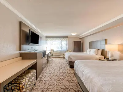 a hotel room with two beds and a flat screen tv at Amanzi Hotel, an Ascend Collection Hotel in Ventura