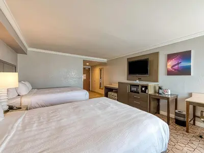 a hotel room with two beds and a flat screen tv at Amanzi Hotel, an Ascend Collection Hotel in Ventura