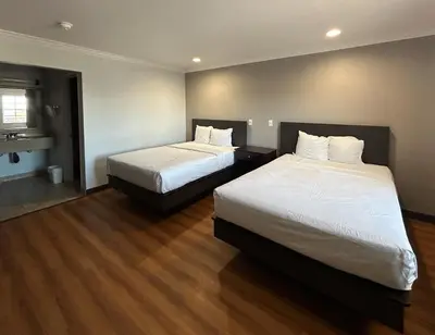 two beds in a hotel room with wood floors at Studio 6 Mojave, CA - Airport in Mojave