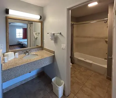a bathroom with a sink and a mirror and a tub at Studio 6 Mojave, CA - Airport in Mojave