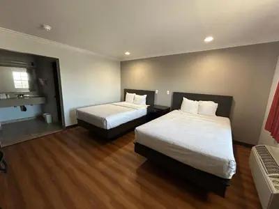 two beds in a hotel room with wood floors at Studio 6 Mojave, CA - Airport in Mojave