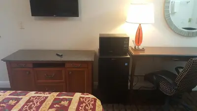 a bedroom with a desk and a bed and a desk with a lamp at Flamingo Inn Long Beach in Long Beach