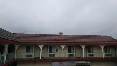 a building with a red roof and a balcony at Flamingo Inn Long Beach in Long Beach