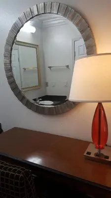 a mirror on top of a table with a lamp at Flamingo Inn Long Beach in Long Beach