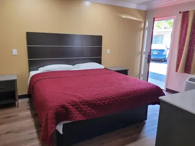 a bedroom with a large bed with a red bedspread at ACE Motel in Pasadena