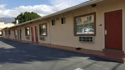 a row of buildings with red doors on a street at ACE Motel in Pasadena