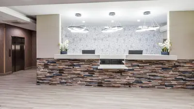 an image of a lobby with a stone wall at Hollywood Inn Suites Hotel in Los Angeles