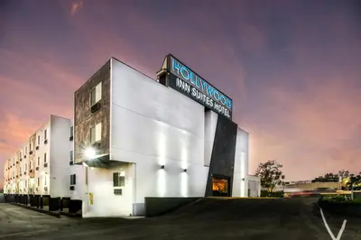 a white building with a sign on top of it at Hollywood Inn Suites Hotel in Los Angeles