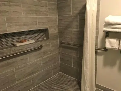 a bathroom with a shower with gray tiles at Desert Inn in Mojave