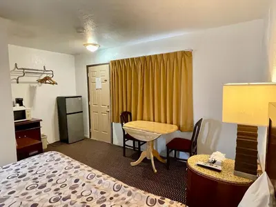 a hotel room with a bed and a desk and a table at Desert Inn in Mojave