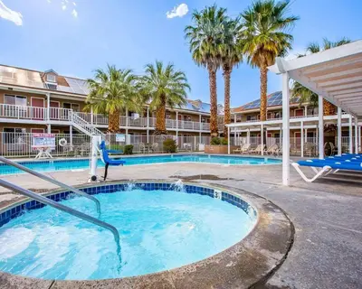 a large swimming pool with palm trees and a slide at Clarion Inn Near China Lake Naval Station in Ridgecrest