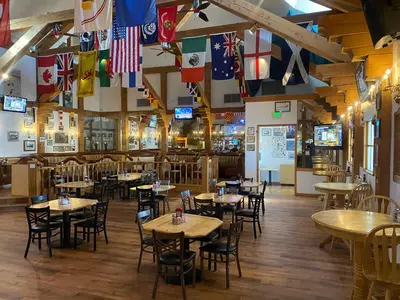 a restaurant with tables and chairs and flags at Clarion Inn Near China Lake Naval Station in Ridgecrest