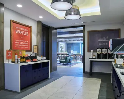 a lobby of a hotel with a coffee shop at Hampton Inn & Suites Sherman Oaks in Sherman Oaks