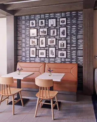 a restaurant with two tables and photos on the wall at Hampton Inn & Suites Sherman Oaks in Sherman Oaks