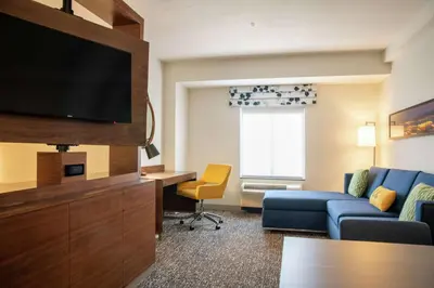 a living room with a couch and a tv in a hotel room at Hampton Inn & Suites Sherman Oaks in Sherman Oaks
