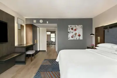 a hotel room with a bed and a desk at Embassy Suites by Hilton Los Angeles Downey in Downey