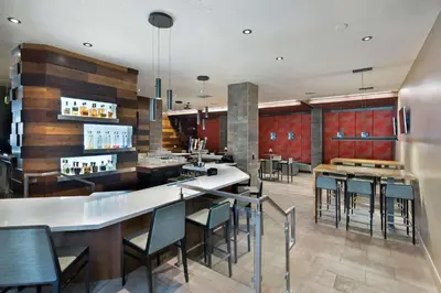 a restaurant with a bar with chairs and tables at Embassy Suites by Hilton Los Angeles Downey in Downey