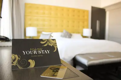 a sign on a table in front of a bed at Padre Hotel in Bakersfield