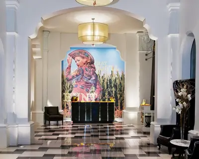a large painting of a woman on a wall in a room at Padre Hotel in Bakersfield