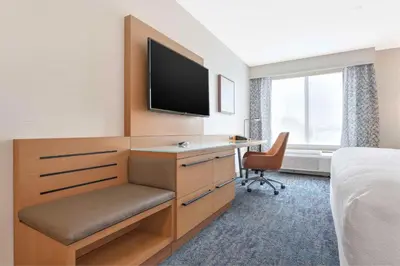 a hotel room with a desk and a flat screen tv at Hilton Garden Inn LAX - El Segundo in El Segundo