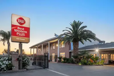 a best western plus sign in front of a hotel at Best Western Plus Hill House in Bakersfield