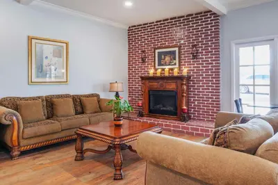 a living room with couches and a brick fireplace at Best Western Plus Hill House in Bakersfield