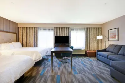 a hotel room with two beds and a desk with a television at Hampton Inn & Suites Los Angeles Burbank Airport in Burbank