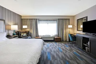a hotel room with a bed and a desk and a television at Hampton Inn & Suites Los Angeles Burbank Airport in Burbank